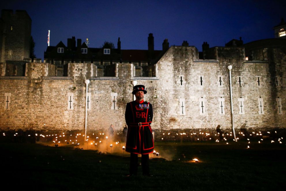 PHOTO: A Yeoman of the Guard stands among lit torches that are part of the installation "Beyond the Deepening Shadow" at the Tower of London, in London, Nov. 4, 2018.