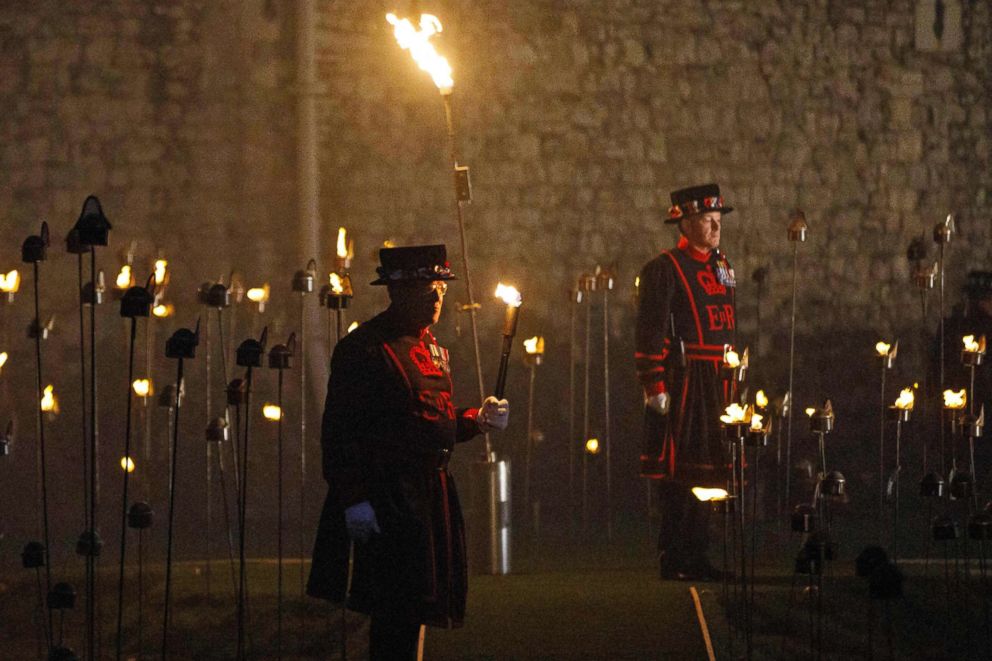 PHOTO: Yeoman Warders, commonly known as a "Beefeaters," stand by after lighting the first of thousands of flames in a lighting ceremony at the Tower of London, Nov. 4, 2018.