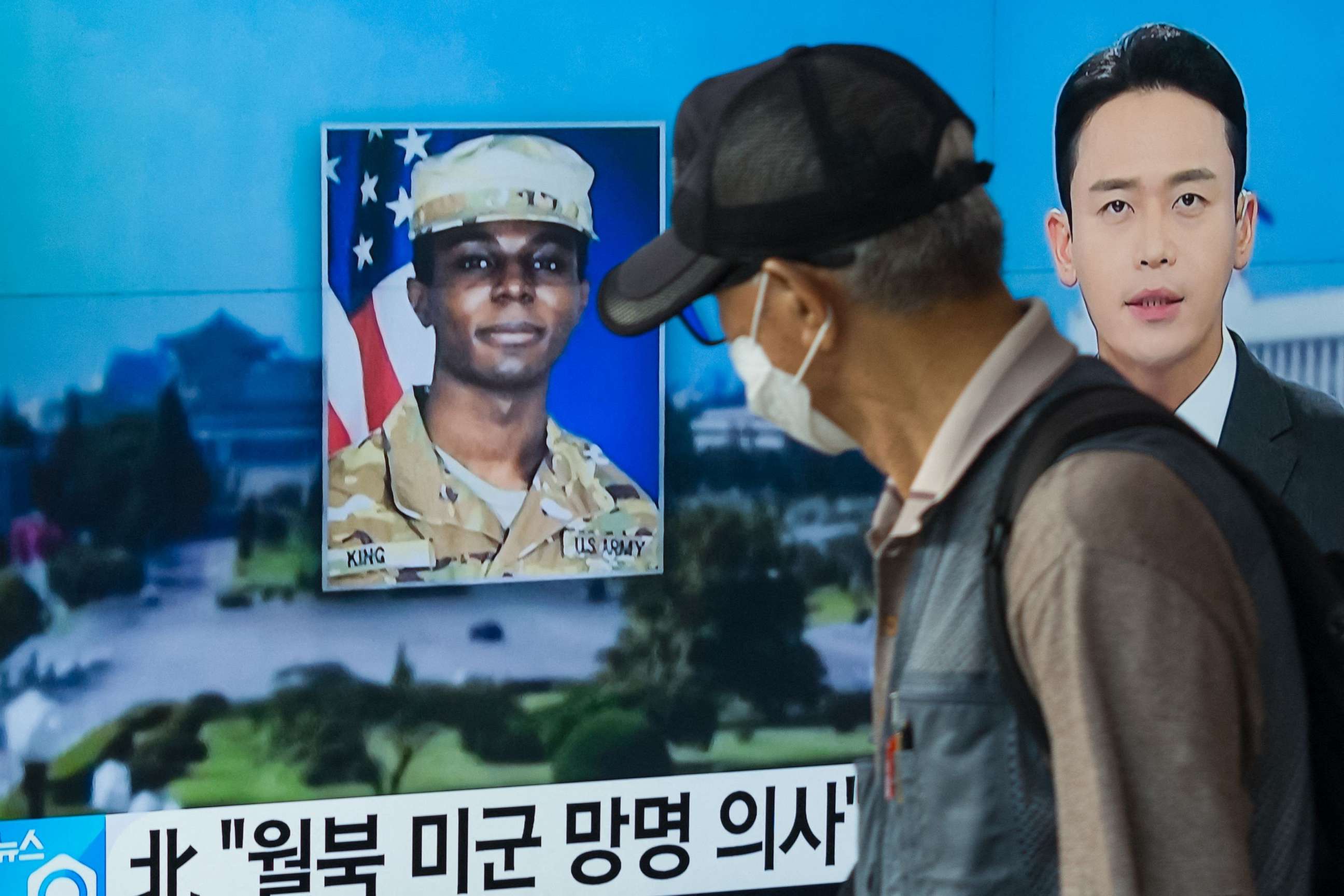 PHOTO: (FILES) In this photo taken in Seoul on August 16, 2023, a man walks past a television showing a news broadcast featuring a photo of US soldier Travis King (C).