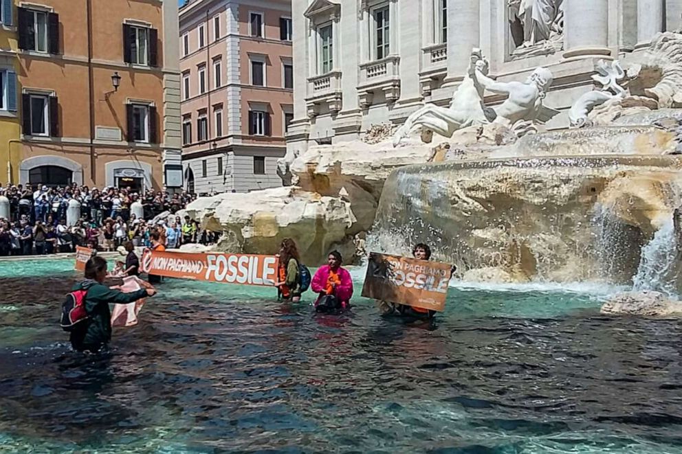 PHOTO: Environmental activists of Last Generation (Ultima Generazione) shows the group's activist holding a banner reading "we don't pay for the fossil" in Rome's historic Fontana di Trevi fountain, May 21, 2023.