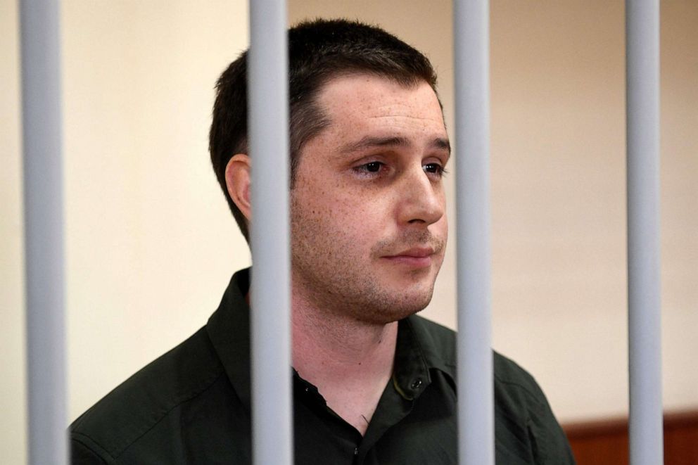 PHOTO: In this file photo taken on March 11, 2020 U.S. ex-marine Trevor Reed, charged with attacking police, stands inside a defendants' cage during a court hearing in Moscow.