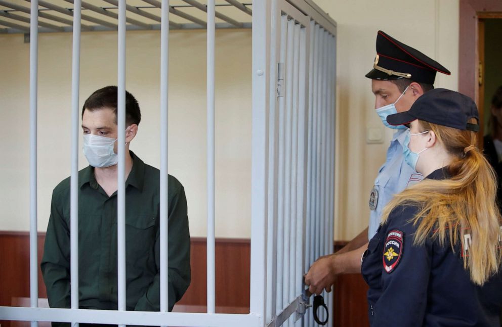 PHOTO: In this July 30, 2020, file photo, former U.S. Marine Trevor Reed, who was detained in 2019 and accused of assaulting police officers, stands inside a defendants' cage during a court hearing in Moscow.
