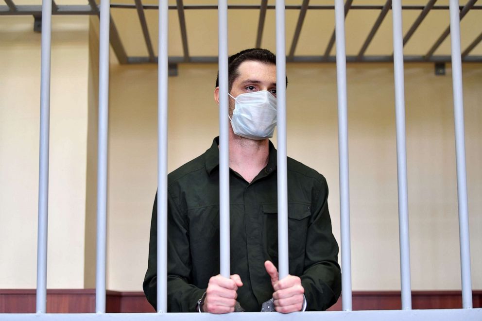 PHOTO: US ex-marine Trevor Reed, charged with attacking police, stands inside a defendants' cage during his verdict hearing at Golovinsky district court in Moscow, July 30, 2020. 