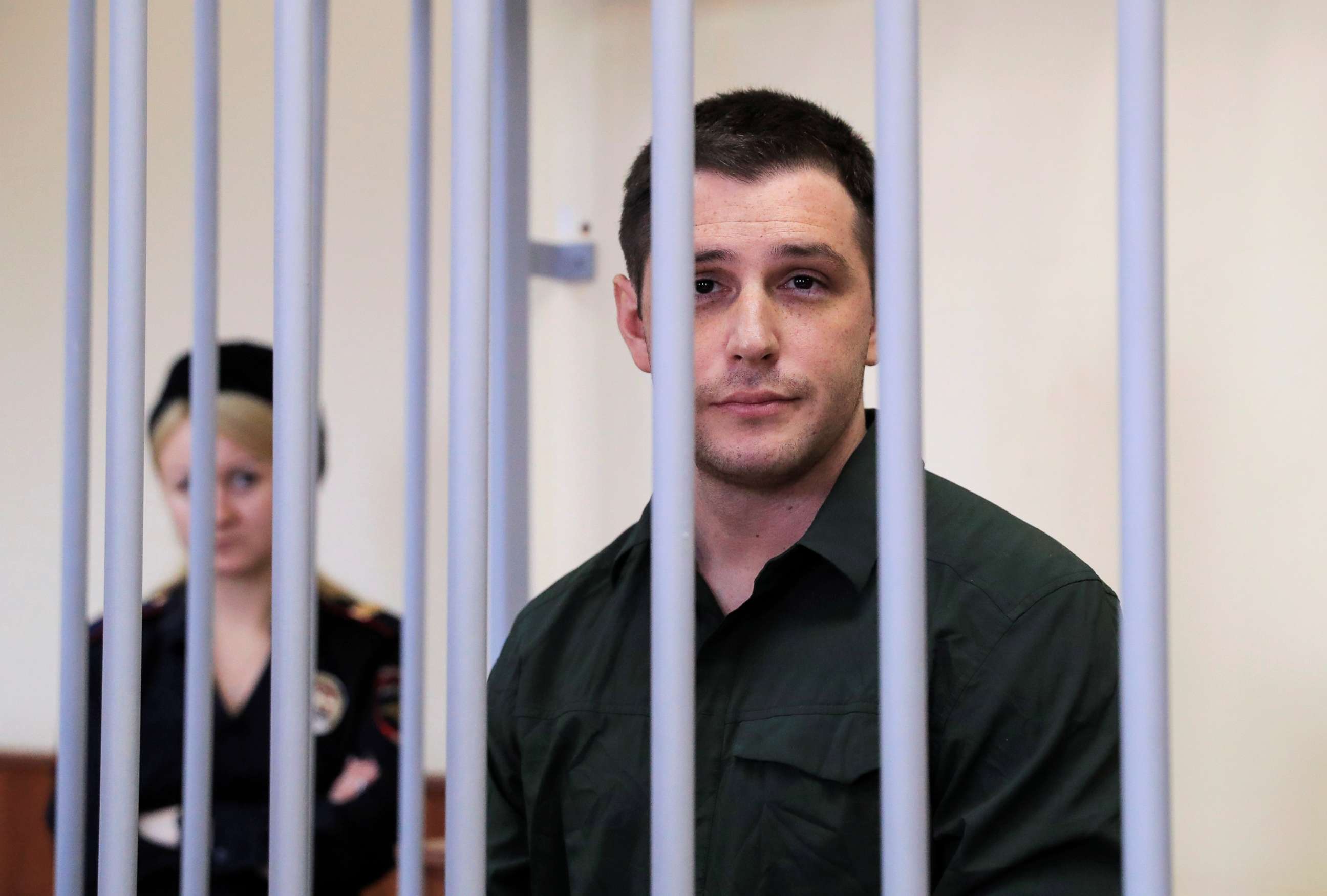 PHOTO: U.S. former Marine Trevor Reed, who was detained in 2019 and accused of assaulting police officers, stands inside a defendants' cage during a court hearing in Moscow, March 11, 2020.