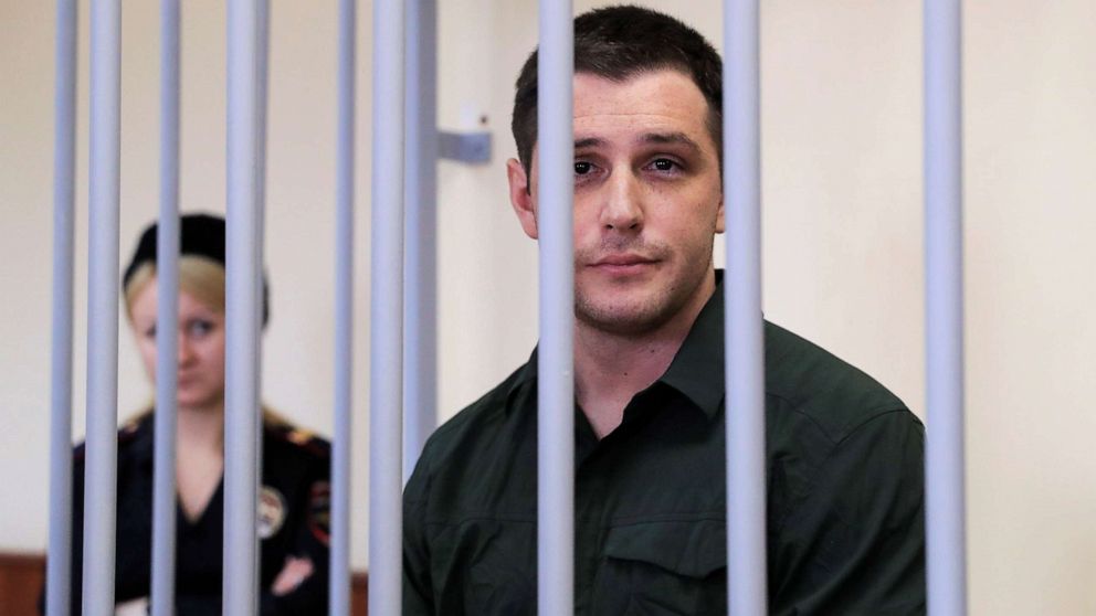 PHOTO: U.S. former Marine Trevor Reed, who was detained in 2019 and accused of assaulting police officers, stands inside a defendants' cage during a court hearing in Moscow, March 11, 2020.