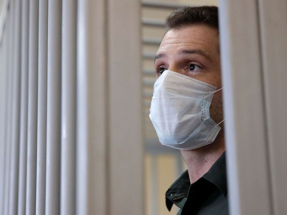 PHOTO: Former U.S. Marine Trevor Reed, who was detained in 2019 and accused of assaulting police officers, stands inside a defendants' cage during a court hearing in Moscow, July 30, 2020.