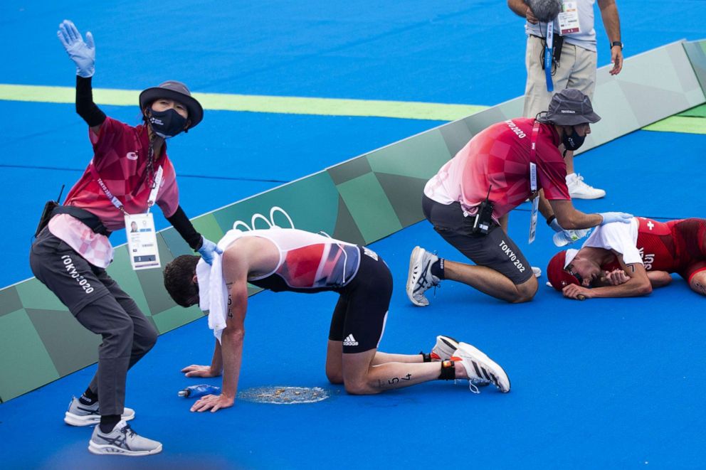 PHOTO: Switzerland's Max Studer, right, and Jonathan Brownlee of Britain are exhausted in the finish area during the men's Individual Triathlon competition at the 2020 Tokyo Summer Olympics in Tokyo, Japan, 26 July 2021.