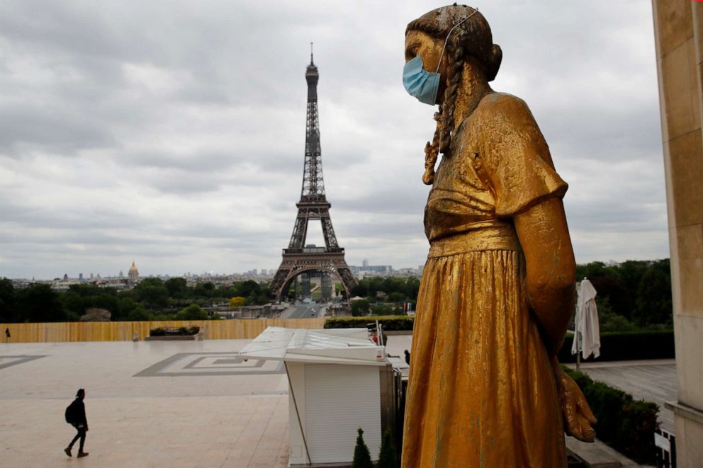 PHOTO: In this file photo dated May 4, 2020, a statue wears a mask along Trocadero square close to the Eiffel Tower in Paris, France.