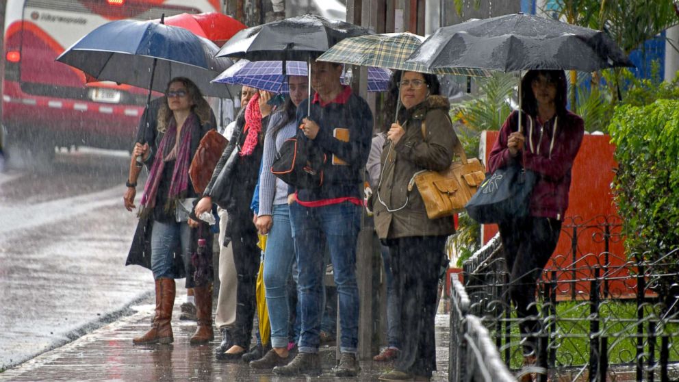 PHOTO: Locals holding umbrellas wait at a bus stop during a downpour caused by tropical storm Nate in Cartago, Costa Rica, Oct. 5, 2017.