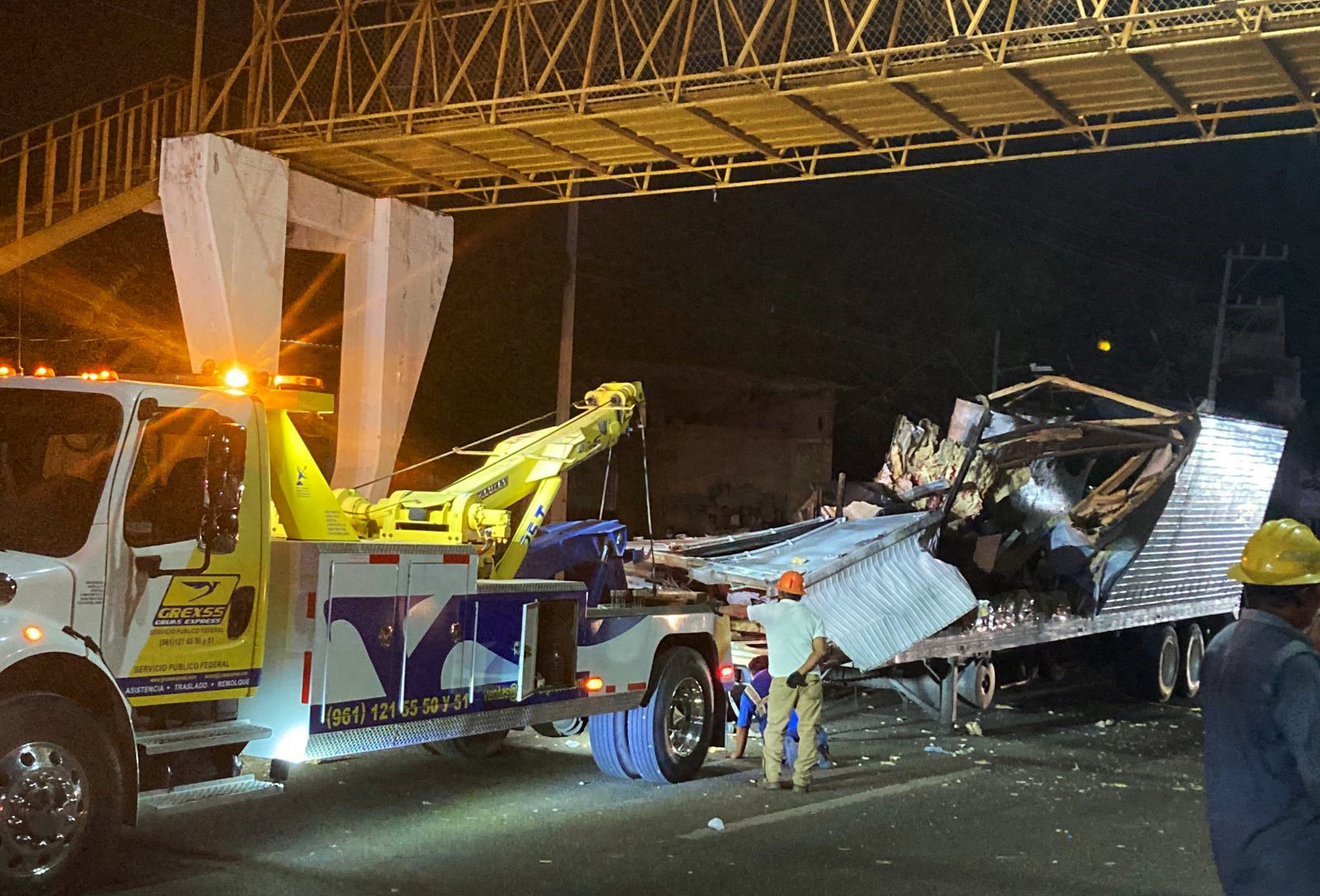 PHOTO: Workers remove the container from the trailer of a truck that crashed with migrants aboard during a road accident in Tuxtla Gutierrez, Chiapas state, Mexico, on December 9, 2021.