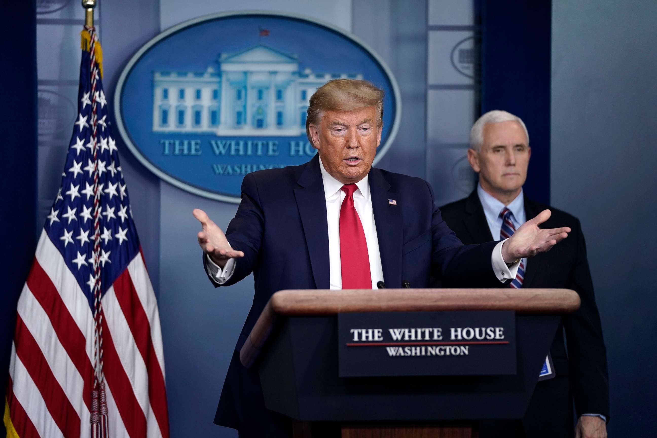 PHOTO: President Donald Trump gestures as Vice President Mike Pence looks on during a briefing on the coronavirus pandemic in the press briefing room of the White House, on March 26, 2020, in Washington.