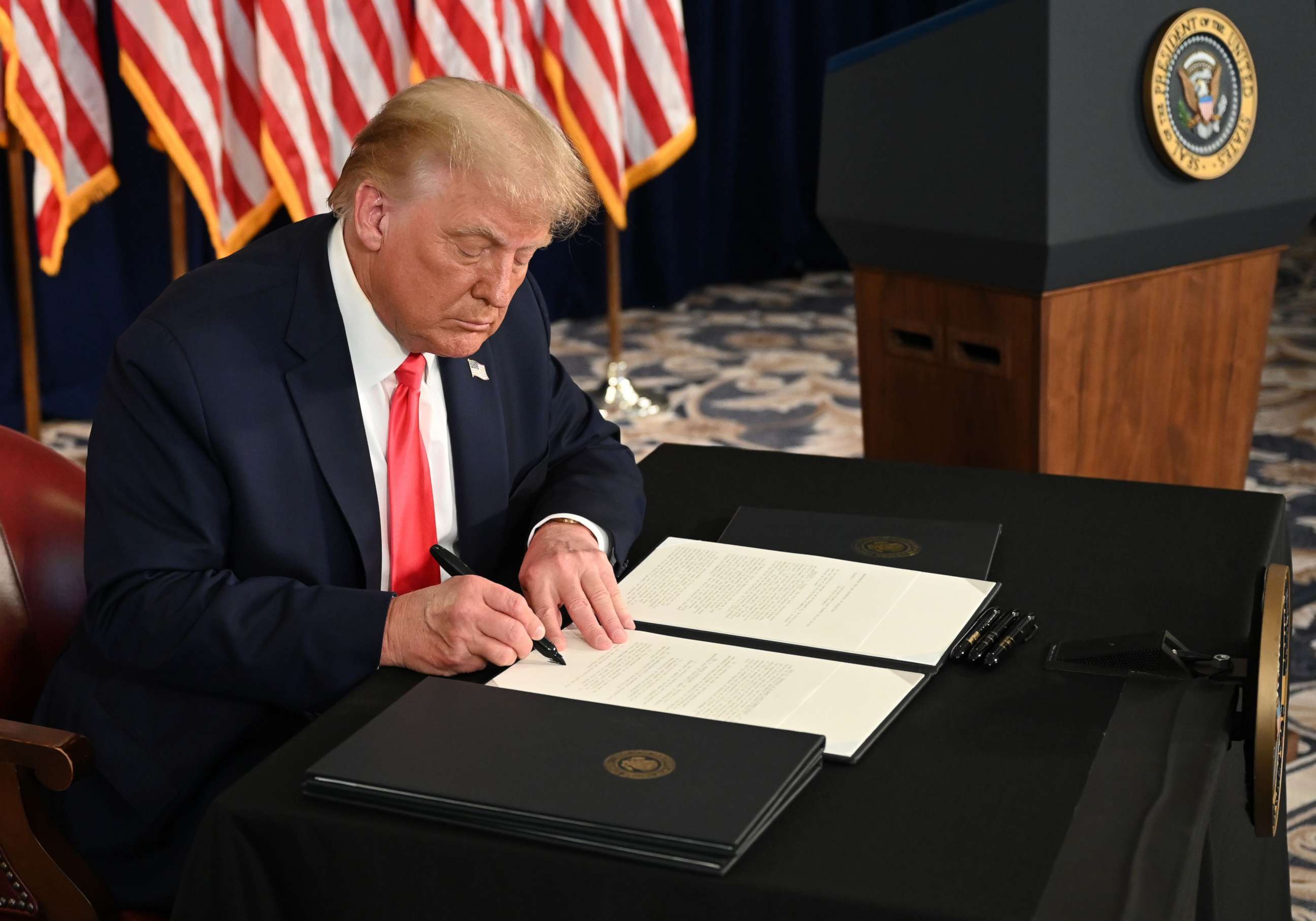 PHOTO: President Donald Trump signs executive orders extending coronavirus economic relief, during a news conference in Bedminster, N.J. on Aug. 8, 2020.