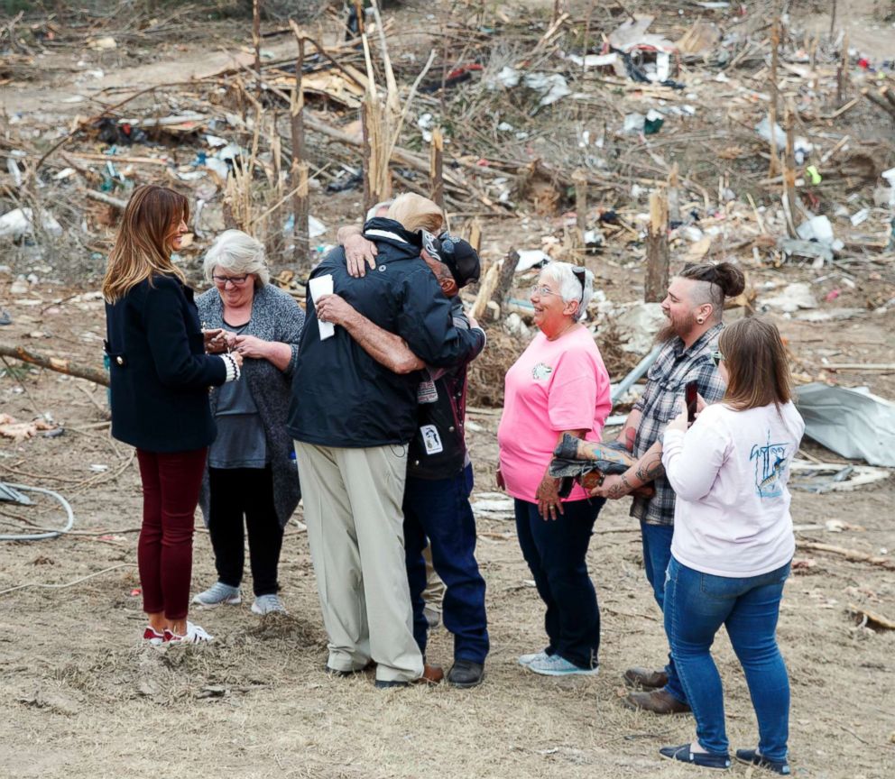 President Donald Trump hugs a resident as he and first lady Melania Trump talk with people in Beauregard, Ala., as they travel to tour areas where tornadoes killed 23 people in Lee County, Ala., March 8, 2019.