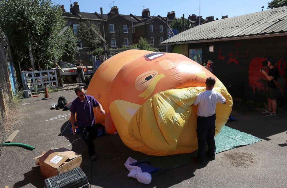 PHOTO: People inflate a helium filled Donald Trump blimp, which they hope to deploy during the President's upcoming visit, in London, June 26, 2018.