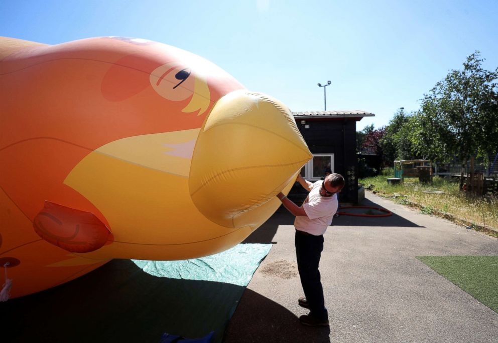PHOTO: People inflate a helium filled Donald Trump blimp, which they hope to deploy during the President's upcoming visit, in London, June 26, 2018.