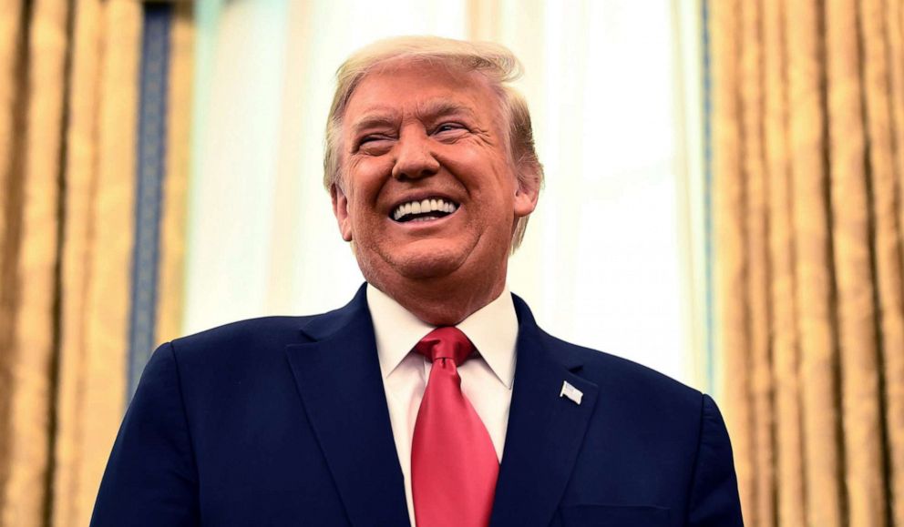 PHOTO: President Donald Trump appears at a ceremony to award the Presidential Medal of Freedom to retired football coach Lou Holtz on Dec. 3, 2020, in the Oval Office of the White House, in Washington.