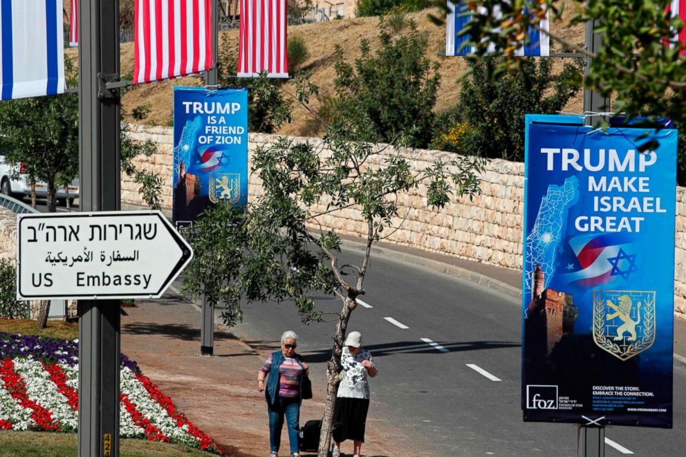 PHOTO: People walk near the compound of the US consulate in Jerusalem, which will host the new US embassy, as posters praising the US president hang in the street, May 11, 2018.