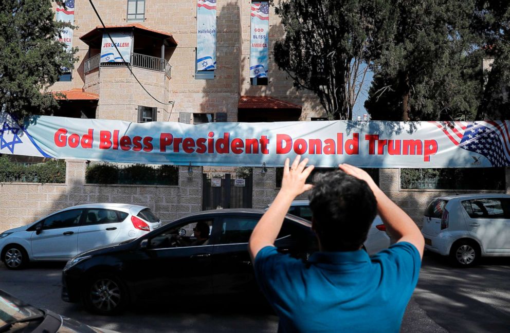 PHOTO: An Israeli man takes a picture, May 11, 2018, of a poster placed near the compound of the US consulate in Jerusalem, which will host the new US embassy, as posters praising the US president hang in the street.