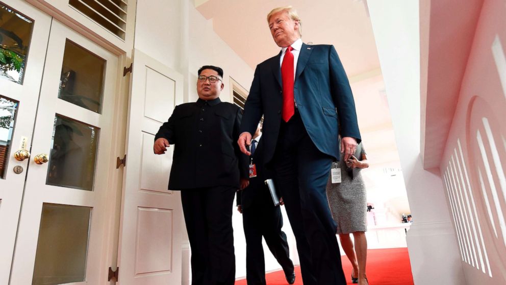 North Korea's leader Kim Jong Un walks with President Donald Trump at the start of their summit, at the Capella Hotel on Sentosa island, in Singapore, on June 12, 2018.
