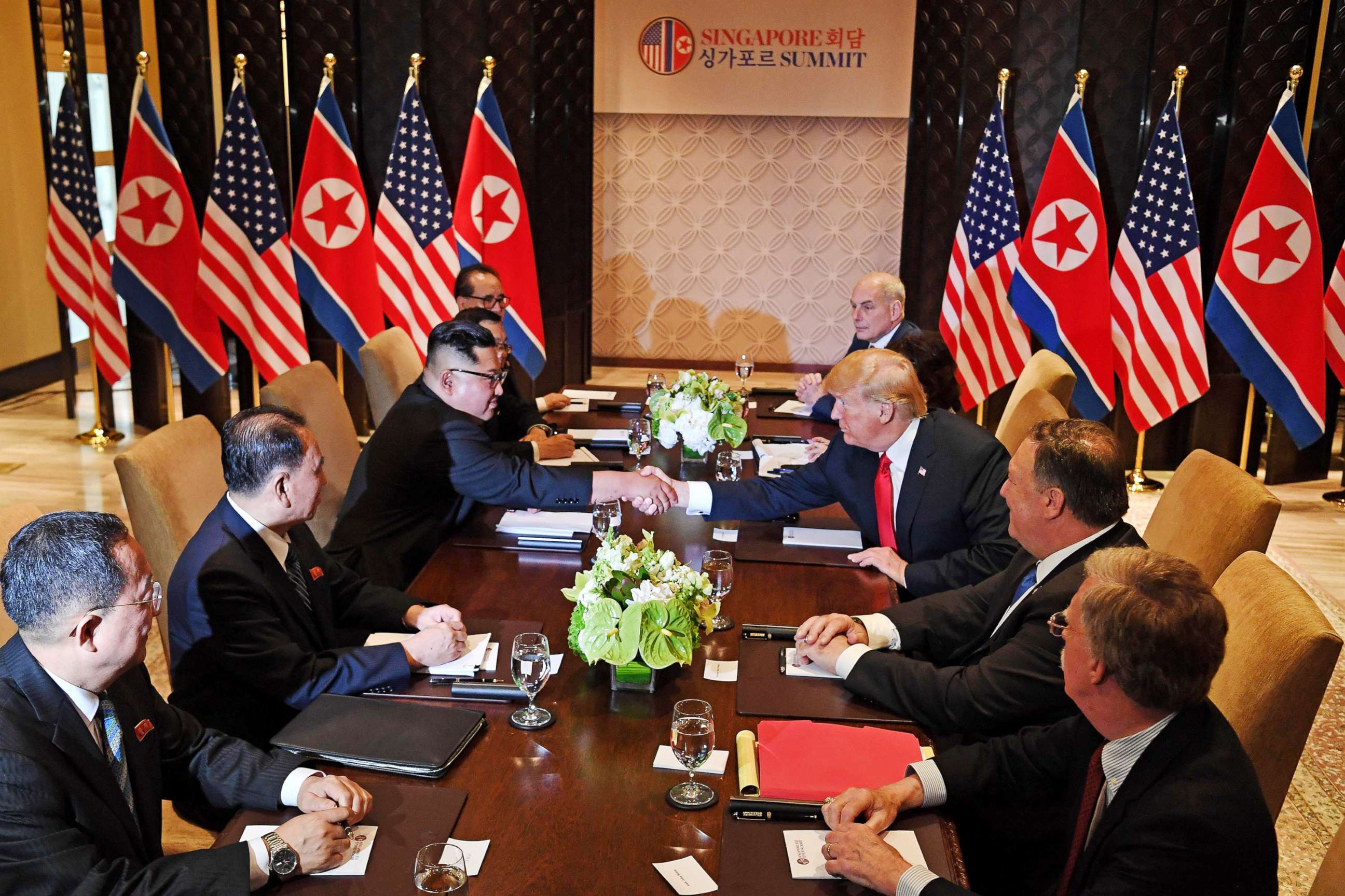 PHOTO: President Donald Trump shakes hands with North Korea's leader Kim Jong Un as they sit down with their respective delegations for the U.S.-North Korea summit, at the Capella Hotel on Sentosa island in Singapore on June 12, 2018.