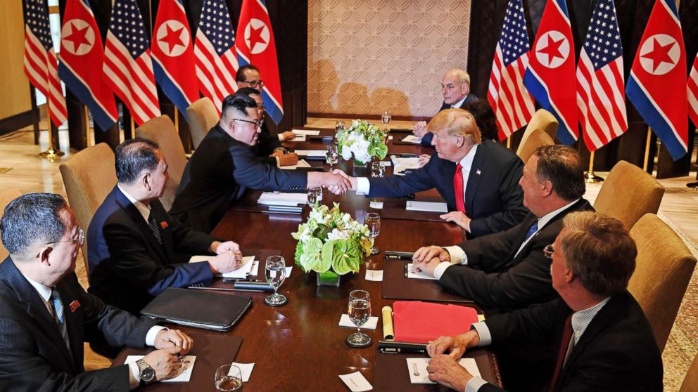 PHOTO: President Donald Trump shakes hands with North Korea's leader Kim Jong Un as they sit down with their respective delegations for the U.S.-North Korea summit, at the Capella Hotel on Sentosa island in Singapore on June 12, 2018.