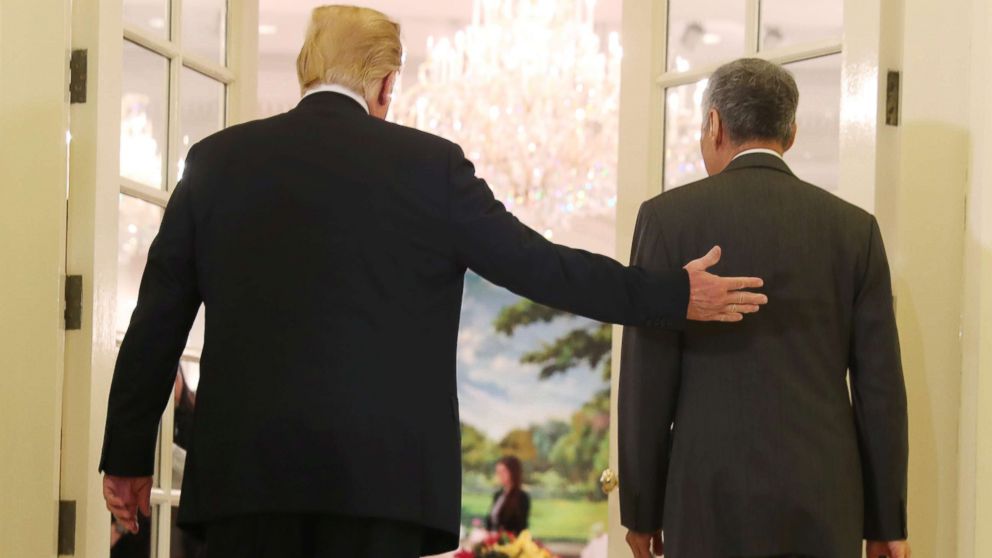 President Donald Trump and Singapore's Prime Minister Lee Hsien Loong walk together during a meeting at the Istana in Singapore June 11, 2018.