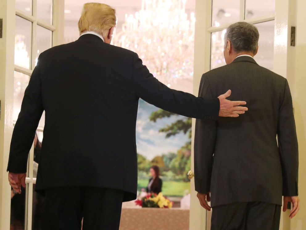 PHOTO: President Donald Trump and Singapores Prime Minister Lee Hsien Loong walk together during a meeting at the Istana in Singapore June 11, 2018.