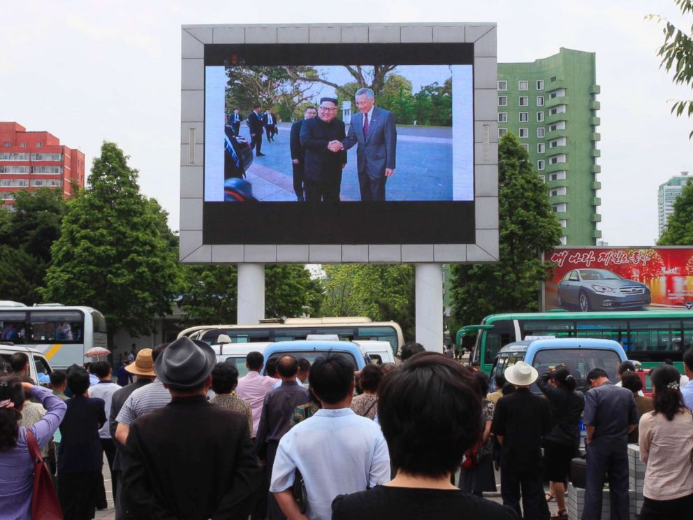 PHOTO: People watch a large screen at the main train station airing video of North Korean leader Kim Jong Un shaking hands with Singapore Prime Minister Lee Hsien Loong during his trip to Singapore in Pyongyang, North Korea, June 11, 2018.