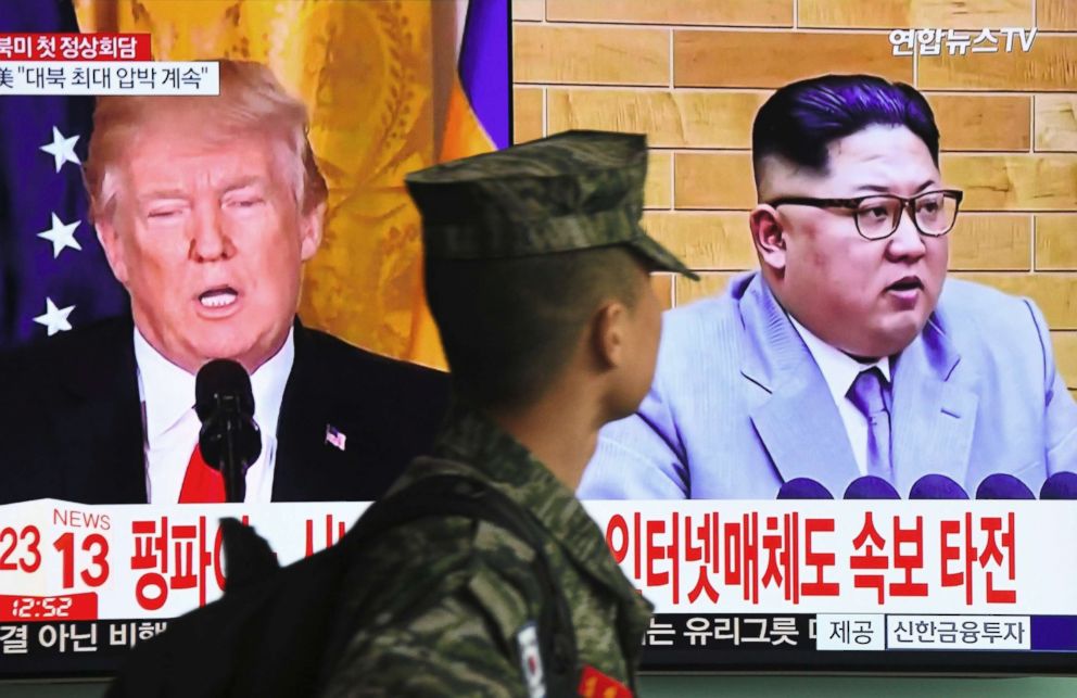 PHOTO: A South Korean soldier walks past a television screen showing pictures of President Donald Trump and North Korean leader Kim Jong Un at a railway station in Seoul on March 9, 2018.