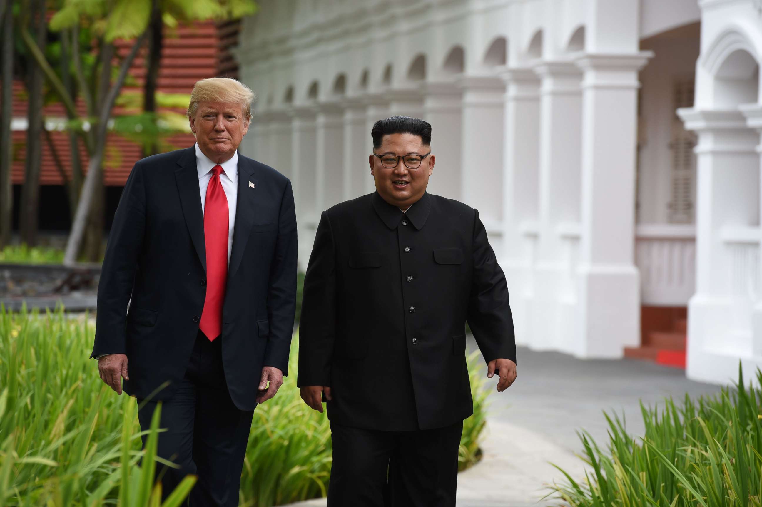 PHOTO: President Donald Trump walks with North Korea's leader Kim Jong Un during a break in talks at their summit, at the Capella Hotel on Sentosa island in Singapore on June 12, 2018.