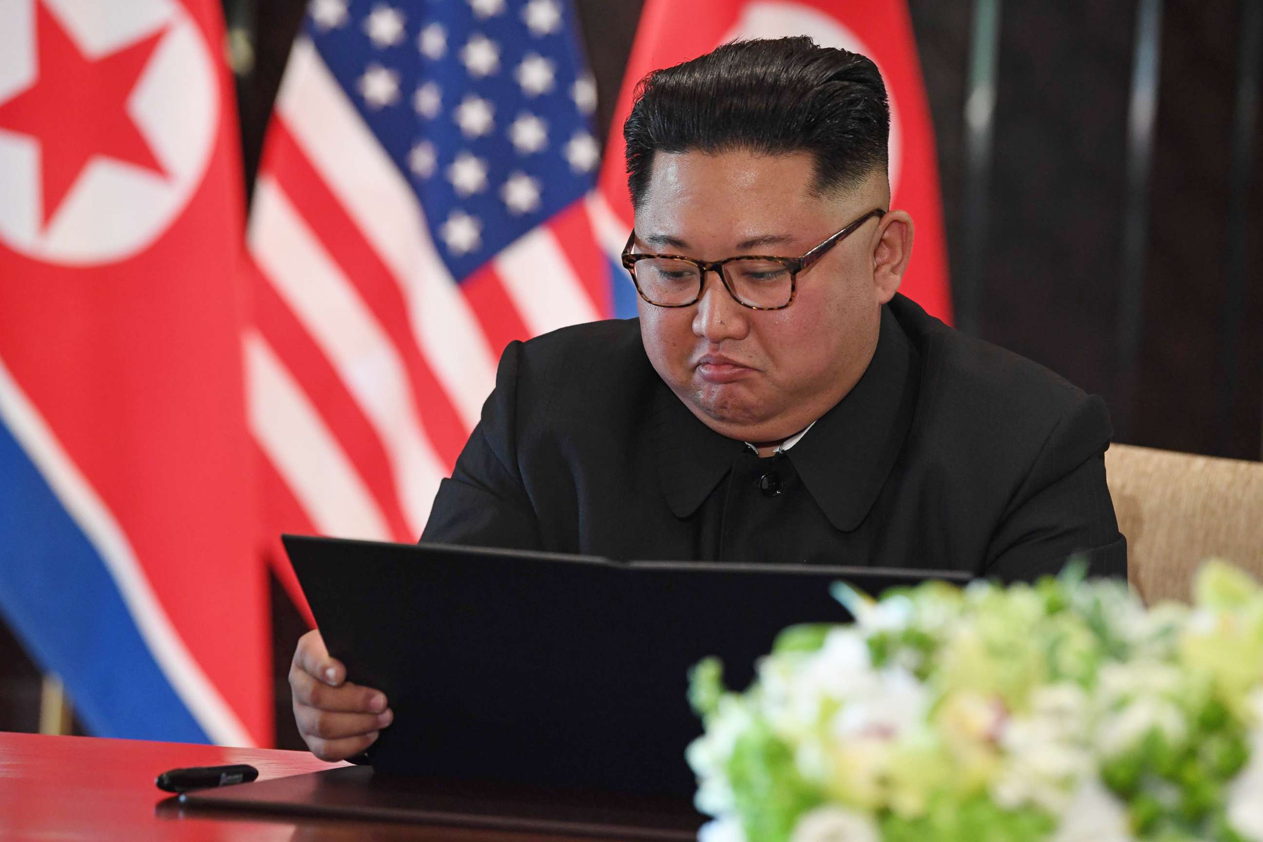 PHOTO: North Korea's leader Kim Jong Un looks at his document at a signing ceremony with President Donald Trump during their summit at the Capella Hotel on Sentosa island in Singapore on June 12, 2018.