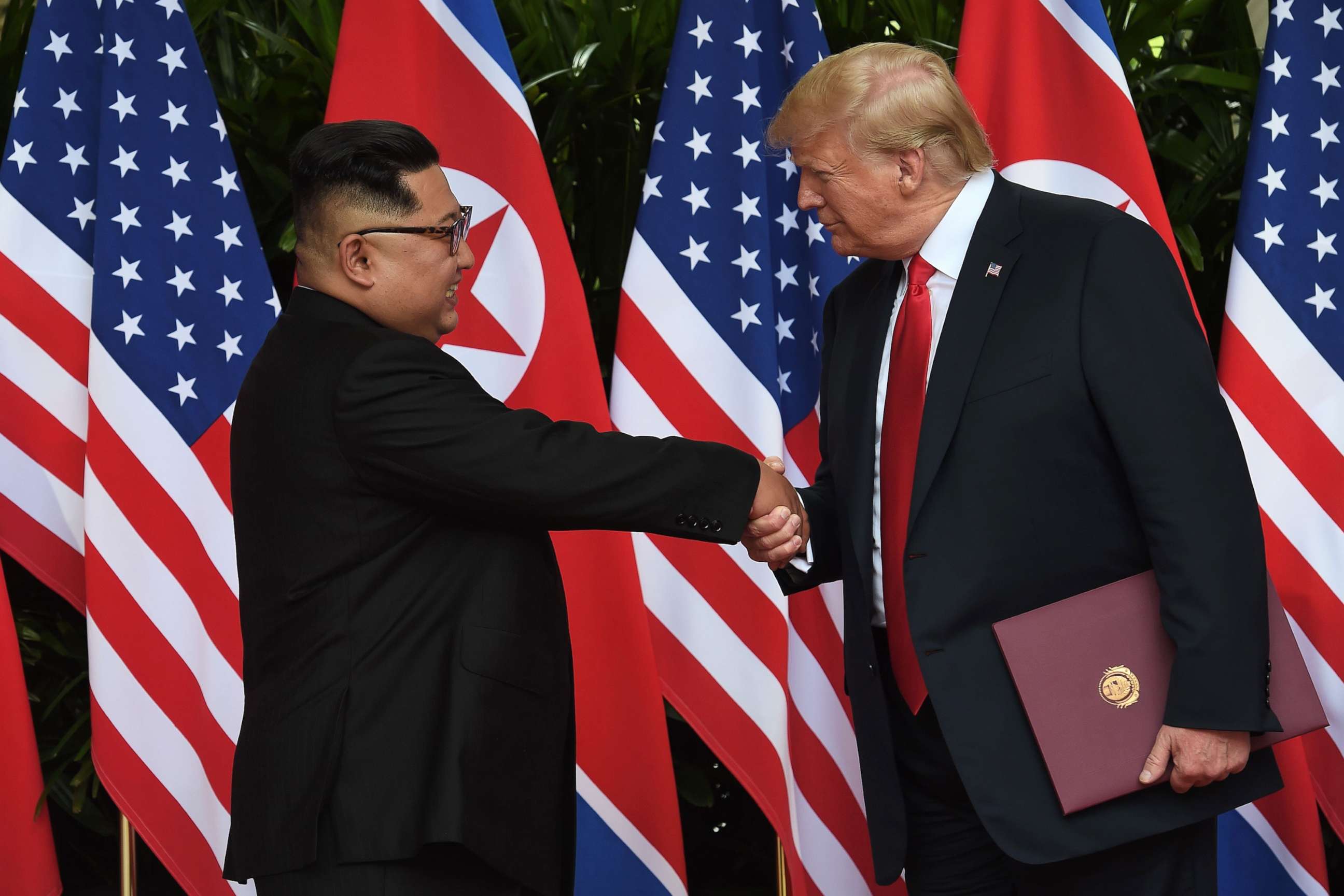 PHOTO: North Korea's leader Kim Jong Un shakes hands with President Donald Trump after taking part in a signing ceremony at the end of their summit at the Capella Hotel on Sentosa island in Singapore on June 12, 2018.