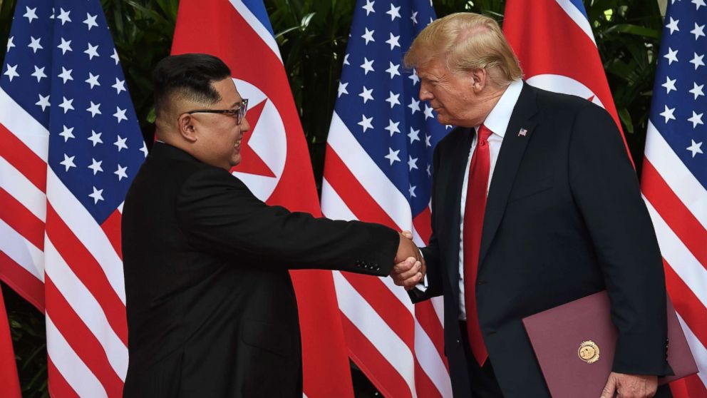 PHOTO: North Korea's leader Kim Jong Un shakes hands with President Donald Trump after taking part in a signing ceremony at the end of their summit at the Capella Hotel on Sentosa island in Singapore on June 12, 2018.