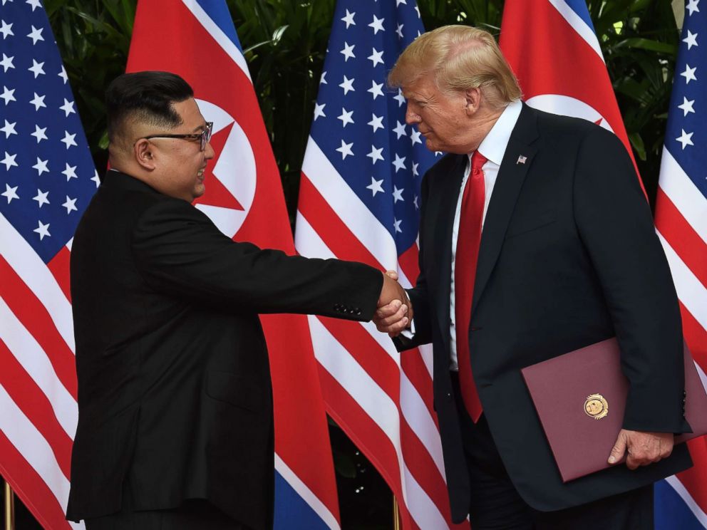 PHOTO: North Koreas leader Kim Jong Un shakes hands with President Donald Trump after taking part in a signing ceremony at the end of their summit at the Capella Hotel on Sentosa island in Singapore on June 12, 2018.