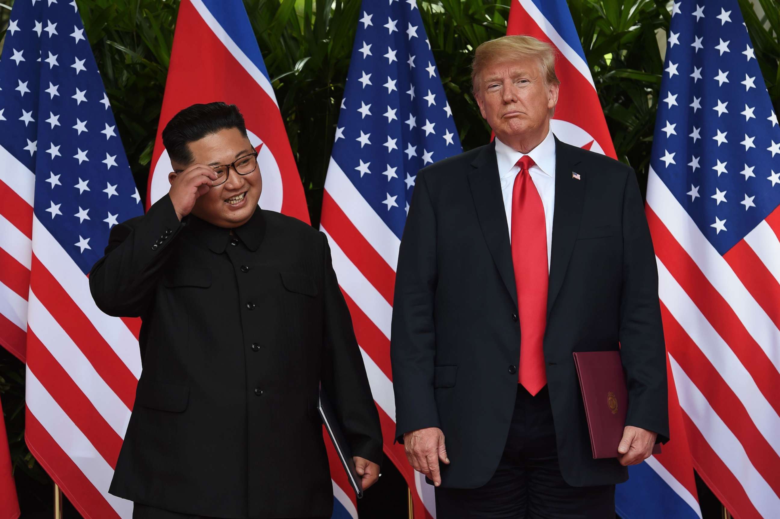 PHOTO: North Korea's leader Kim Jong Un smiles while posing with President Donald Trump after taking part in a signing ceremony at the end of their summit in Singapore, June 12, 2018.