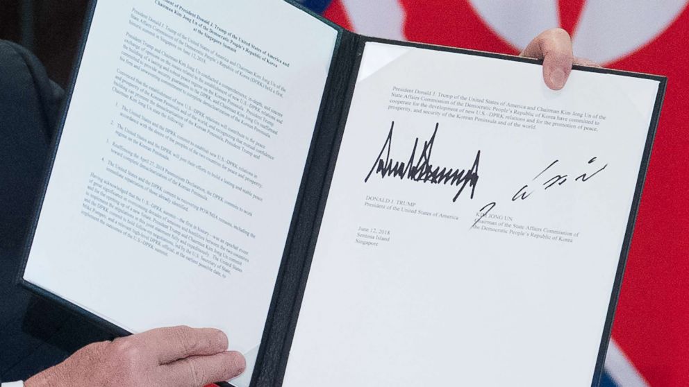 PHOTO: President Donald Trump holds up a document signed by him and North Korea's leader Kim Jong Un following a signing ceremony at the Capella Hotel on Sentosa island in Singapore on June 12, 2018.