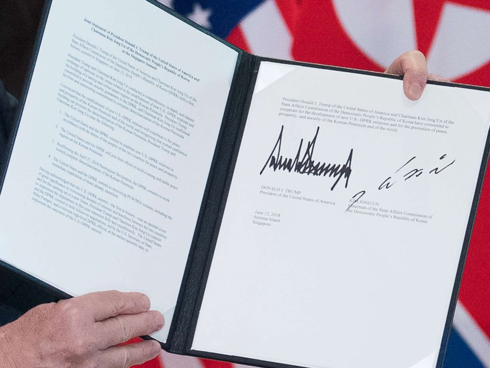 PHOTO: President Donald Trump holds up a document signed by him and North Koreas leader Kim Jong Un following a signing ceremony at the Capella Hotel on Sentosa island in Singapore on June 12, 2018.