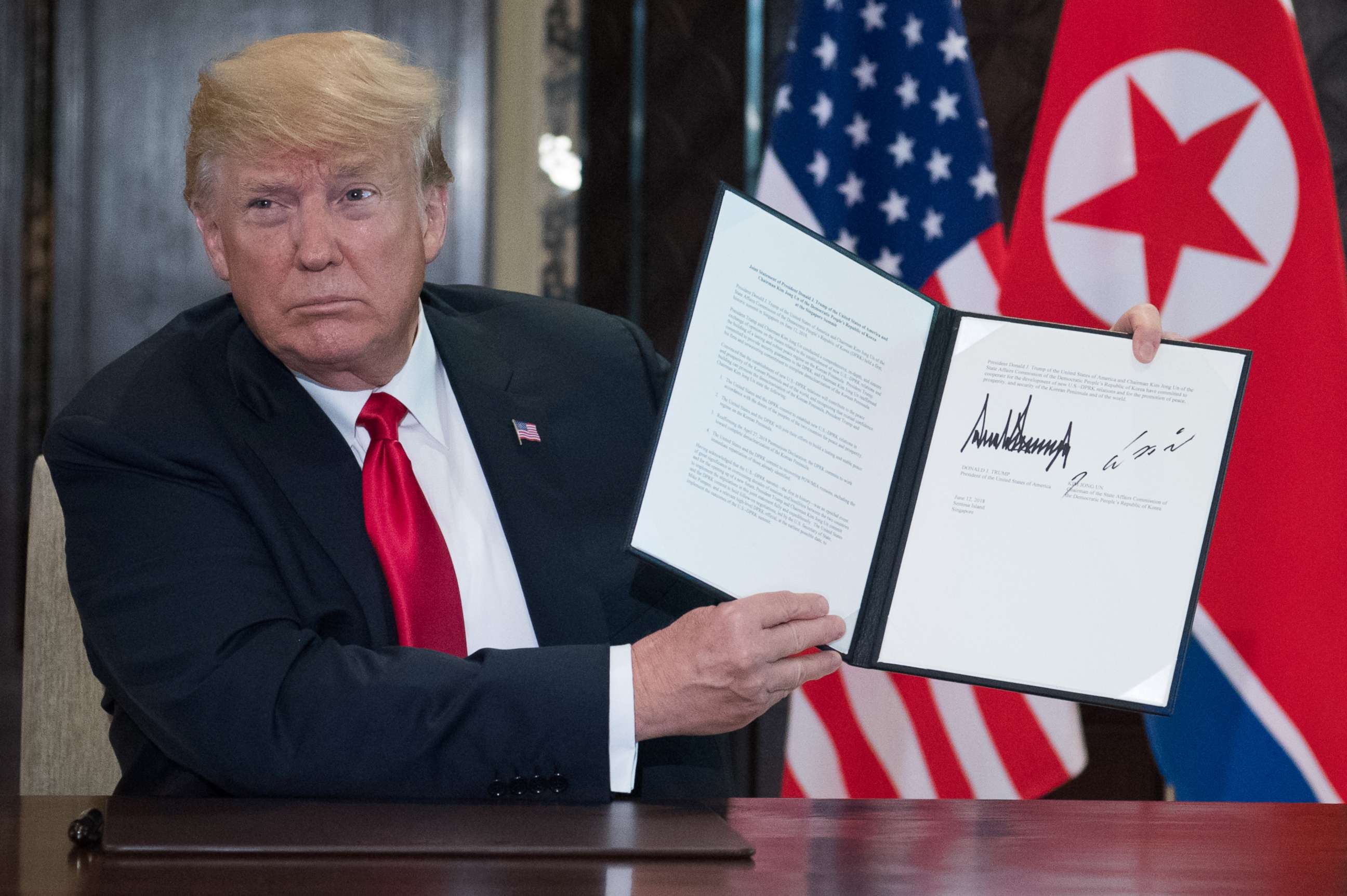 PHOTO: President Donald Trump holds up a document signed by him and North Korea's leader Kim Jong Un following a signing ceremony during their summit at the Capella Hotel on Sentosa island in Singapore on June 12, 2018.