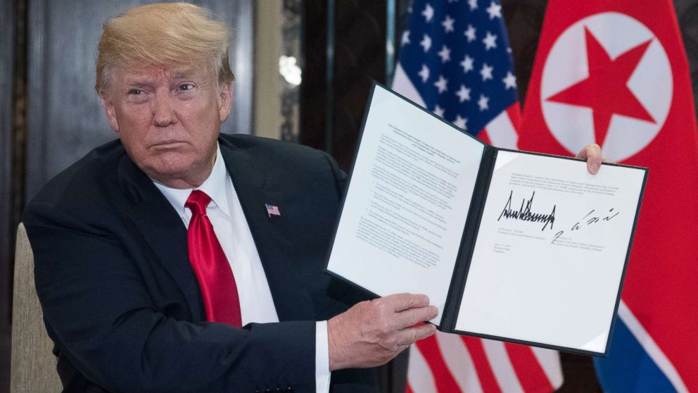 PHOTO: President Donald Trump holds up a document signed by him and North Korea's leader Kim Jong Un following a signing ceremony during their summit at the Capella Hotel on Sentosa island in Singapore on June 12, 2018.