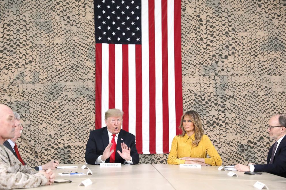 PHOTO: President Donald Trump, flanked by National Security Adviser John Bolton, first lady Melania Trump and U.S. Ambassador to Iraq Doug Silliman, meets political and military leaders during an unannounced visit to Al Asad Air Base, Iraq, Dec. 26, 2018.