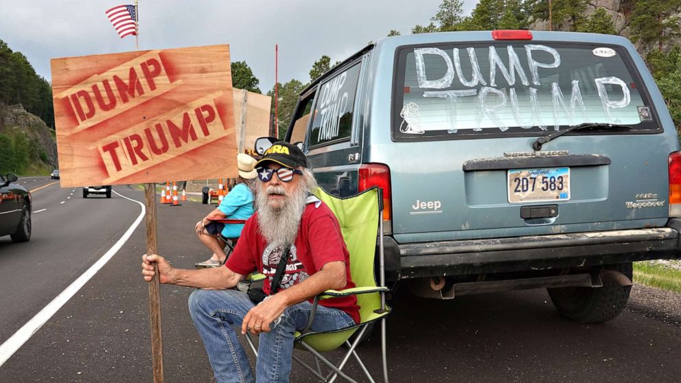 PHOTO: Mike Harris, a retired over-the-road truck driver and registered Republican, shares his views about President Donald Trump with motorists heading toward Mount Rushmore National Monument in Keystone, South Dakota, on July 02, 2020.
