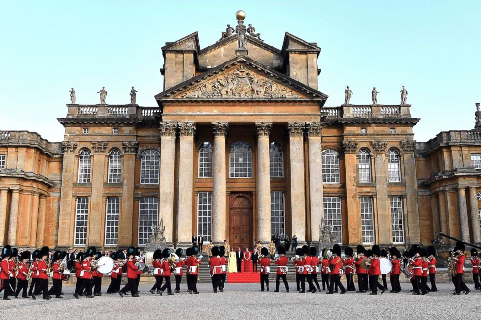 PHOTO: First Lady Melania Trump, President Donald Trump, Britain's Prime Minister Theresa May and Philip May, stand on steps in the Great Court watching and listening to bands as they arrive for dinner at Blenheim Palace, west of London, July 12, 2018.