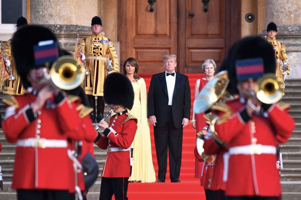 PHOTO: Britain's Prime Minister Theresa May (R) President Donald Trump and his wife First Lady Melania Trump stand on steps in the Great Court watching and listening to bands perform a ceremonial welcome at Blenheim Palace, west of London, July 12, 2018.