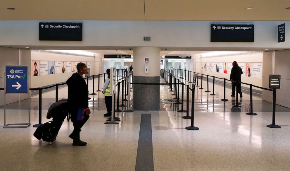 PHOTO: Passengers head to the TSA security checkpoint at Midway International Airport, March 30, 2020, in Chicago.