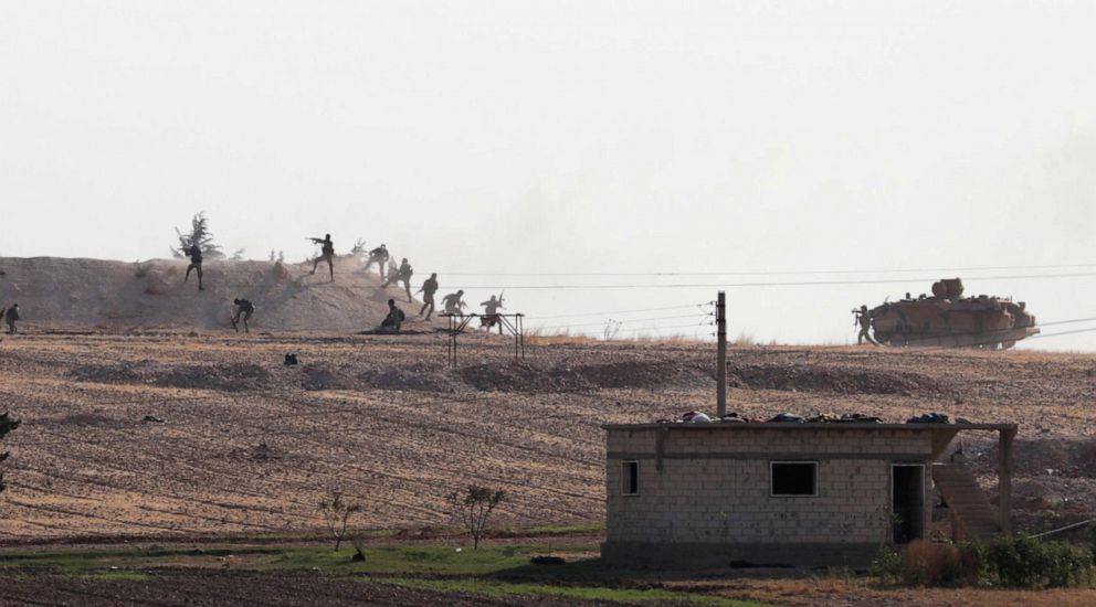 PHOTO: Turkey-backed Syrian rebel fighters are seen in action in the village of Yabisa, near the Turkish-Syrian border, Syria, Oct. 13, 2019. 