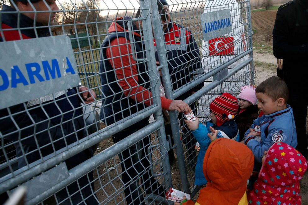 PHOTO: An NGO worker distributes milk to kids as they stand near the border crossing at the Pazarakule gate near Edirne, at the Turkish-Greek border, March 2, 2020. 