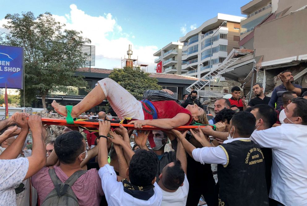 PHOTO: Rescue workers and local people carry a wounded person found in the debris of a collapsed building, in Izmir, Turkey, Oct. 30, 2020, after a strong earthquake in the Aegean Sea shook Turkey and Greece.