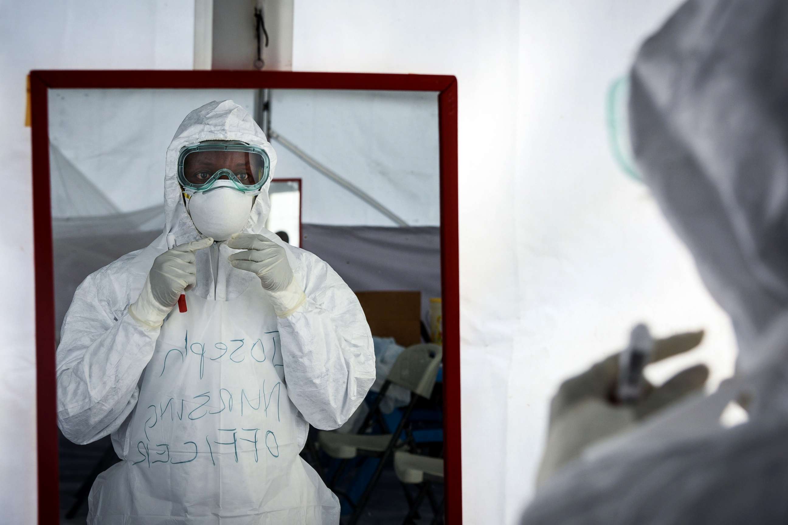 PHOTO: A member of the medical staff of the Ebola Treatment Unit (ETU) checks her Personal Protective Equipment (PPE) in front of the mirror during a weekly rehearsal at the Bwera General Hospital in Bwera, western Uganda, Dec. 12, 2018. 
