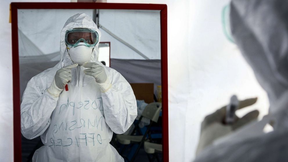 PHOTO: A member of the medical staff of the Ebola Treatment Unit (ETU) checks her Personal Protective Equipment (PPE) in front of the mirror during a weekly rehearsal at the Bwera General Hospital in Bwera, western Uganda, Dec. 12, 2018.