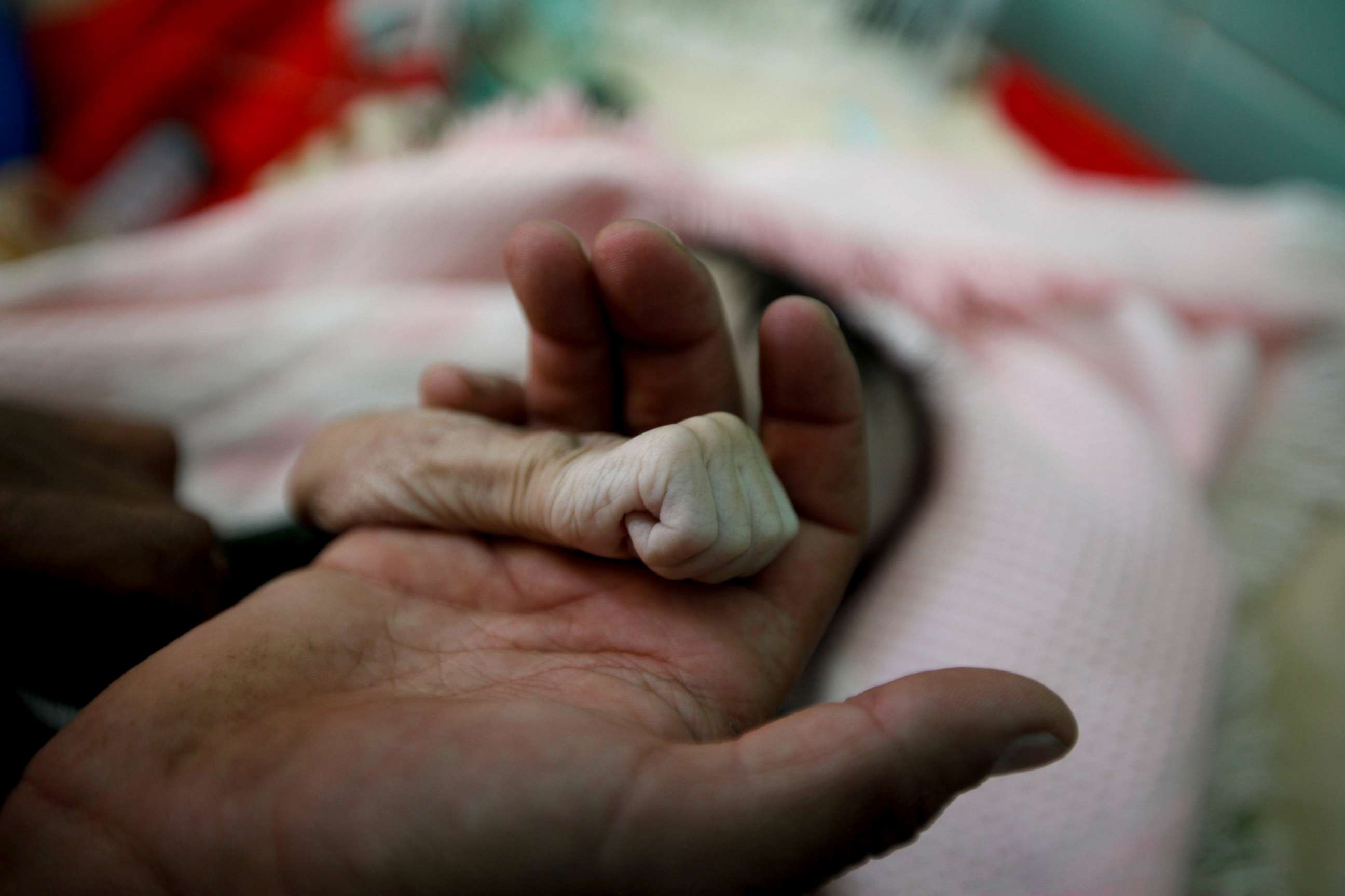 PHOTO: Saleh Hassan al-Faqeh holds the hand of his four-month-old daughter, Hajar, who died of malnutrition at the al-Sabeen hospital in Sanaa, Yemen, Nov. 15, 2018. "She was like skin on bones, her body was emaciated," he said.
